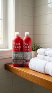 Bed Head by TIGI Resurrection 750ml shampoo and conditioner bottles standing side by side on a bathroom shelf beside fresh white towels.