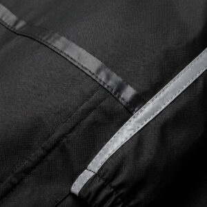 Close-up of the 33,000ft rain suit showing heat-sealed waterproof seams, 100% nylon fabric, and reflective strip piping on the sleeve.