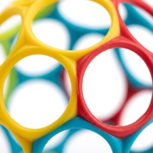 Close-up of the Bright Starts Oball showing its 32 finger-hole mesh design and flexible BPA-free plastic construction.