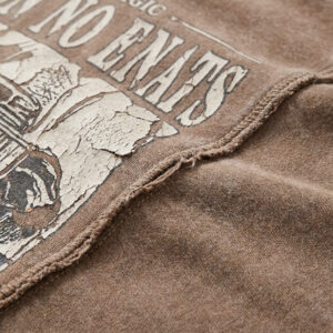 Close-up of a washed vintage oversized graphic t-shirt showing its distressed graphic print, soft cotton-blend texture, and dropped shoulder stitching.