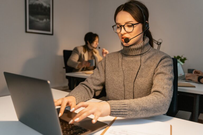 bdynamicshub team member working on a laptop with a headset